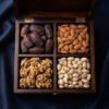 A 4-compartment handcrafted dark mahogany wooden box filled with jumbo Medjool dates, Mamra almonds, akhrot walnuts and roasted pistachios, overhead studio presentation on silk fabric