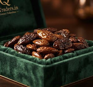 Crinkled premium organic Mamra almonds displayed on a rich green velvet luxury container, with golden almond oil glistening on surface, warm dark background