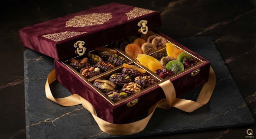 Extravagant royal velvet gift box opened with compartments filled with stuffed dates and exotic dried fruit treats tied with golden silk ribbon.