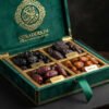 Luxury emerald green velvet keepsake gift box opened to reveal four partitioned compartments containing Ajwa, Medjool, Kalmi, and Sukkari dates, embossed with gold Arabic calligraphy crest and silk ribbon.