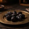 Seven Ajwa dates on antique brass saucer bathed in warm light