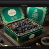 Slender jet-black Royal Kalmi Safawi dates in an emerald gift tin.