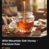 Thick golden raw wild mountain Sidr honey flowing from a traditional wooden dipper into a crystal jar, illuminated by warm morning sun.