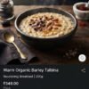Warm bowl of organic barley Talbina porridge garnished with chopped Ajwa dates, ground almonds, and wild saffron.